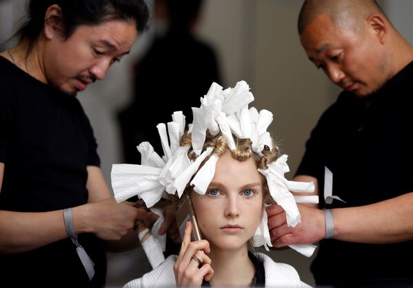 Стилисттер Christian Dior мода үйүнүн жаңы коллекциясын Токиодо көрсөтүү учурунда подиумга моделди даярдап жатышат - Sputnik Кыргызстан
