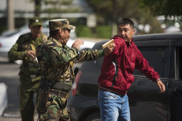 Преступник с деревянным пистолетом. Его задерживают и выводят из машины - Sputnik Кыргызстан