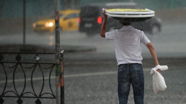 Жаан учурунда көчөдө бараткан адам. Архив - Sputnik Кыргызстан