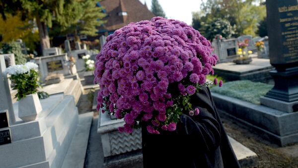 Женщина с цветами на кладбище. Архивное фото - Sputnik Кыргызстан