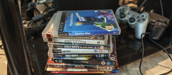 Стопка видеоигр и джойстик игровой консоли. Архивное фото - Sputnik Кыргызстан