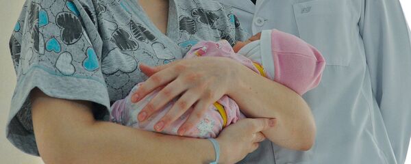 Женщина с новорожденным ребенком в руке. Архивное фото - Sputnik Кыргызстан