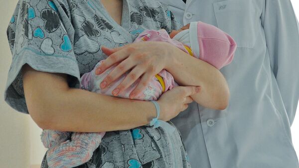 Девушка с грудным ребенком на руках. Архивное фото - Sputnik Кыргызстан