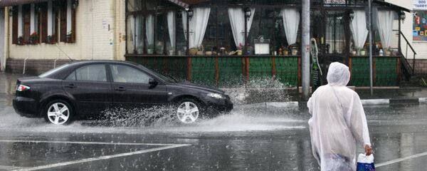 Женщина в дождевике во время непогоды. Архивное фото - Sputnik Кыргызстан