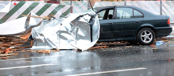 Сорванный ураганом рекламный щит на припаркованном автомобиле в Москве. - Sputnik Кыргызстан