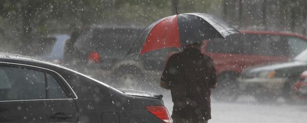 Мужчина с зонтом во время сильного дождя. Архивное фото - Sputnik Кыргызстан