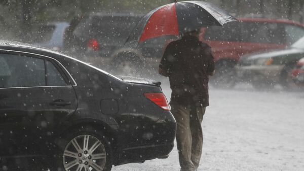 Мужчина с зонтом во время сильного дождя. Архивное фото - Sputnik Кыргызстан