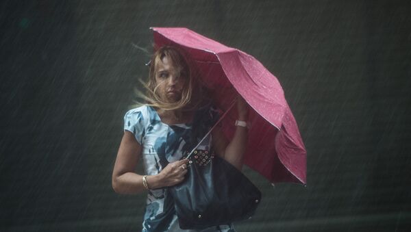 Женщина с зонтиком под сильным дождем и сильным ветром. Архивное фото - Sputnik Кыргызстан