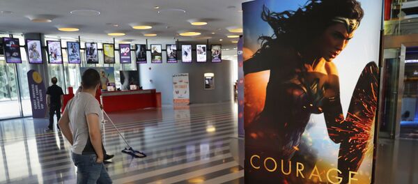 Мужчина проходит мимо плаката, рекламирующего фильм Чудо-женщина в кинотеатре - Sputnik Кыргызстан