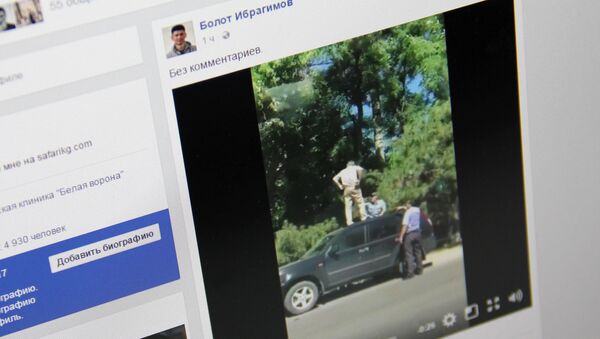 Два инспектора патрульной милиции пытаются снять с крыши автомобиля пожилого мужчину. Фото со страницы Facebook пользователя Болот Ибрагимов - Sputnik Кыргызстан