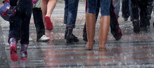 Прохожие идут по улице во время ливня. Архивное фото Прохожие идут по улице во время ливня. Архивное фото - Sputnik Кыргызстан