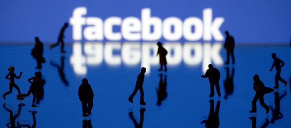 Силуэты людей на фоне логотипа социальной сети Facebook Силуэты людей на фоне логотипа социальной сети Facebook - Sputnik Кыргызстан