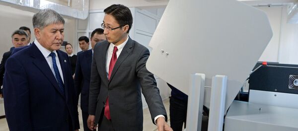 Президент КР Алмазбек Атамбаев и заместитель председателя Государственной регистрационной службы Дастан Догоев (справа) во время ознакомления в работой системы изготовления биометрических электронных паспортов - Sputnik Кыргызстан
