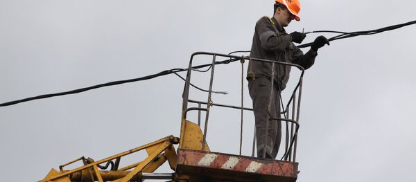 Сотрудник коммунальной службы восстанавливает линию электропередач. Архивное фото Сотрудник коммунальной службы восстанавливает линию электропередач. Архивное фото - Sputnik Кыргызстан