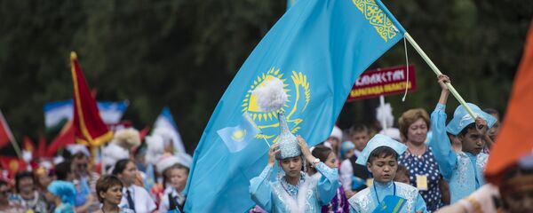 Участники праздничных мероприятий с флагом Казахстана. Архивное фото - Sputnik Кыргызстан