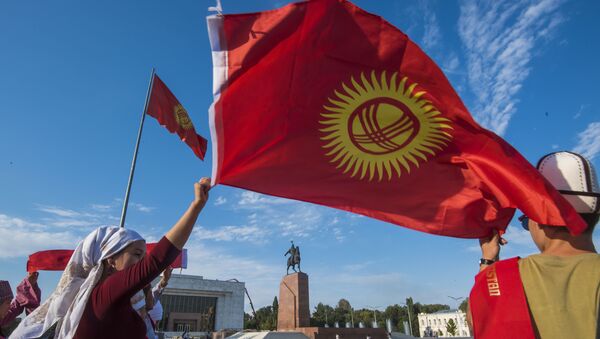 Люди с национальным флагом на площади Ала-Тоо в Бишкеке. Архивное фото - Sputnik Кыргызстан