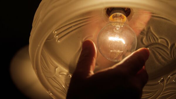 Мужчина откручивает лампочку. Архивное фото - Sputnik Кыргызстан