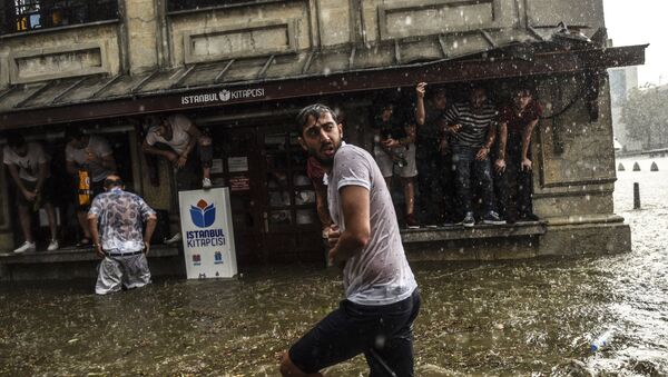 Жители Стамбула во время сильного ливня в районе Бешикташ в Стамбуле. 27 июля 2017 года - Sputnik Кыргызстан