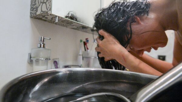 Девушка моет голову нагретой водой. Архивное фото - Sputnik Кыргызстан