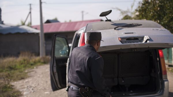 Сотрудник милиции проверят багажник автомобиля. Архивное фото - Sputnik Кыргызстан