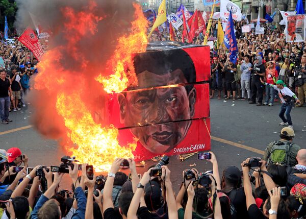 Манилада каршылык акциясына чыккандар Филиппиндердин президенти Родриго Дутертенин сүрөтүн өрттөп жатышат - Sputnik Кыргызстан