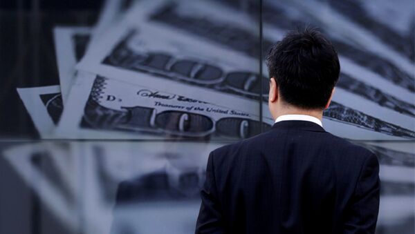 Мужчина в костюме смотрит на экран с фотографией банкнот США. Архивное фото - Sputnik Кыргызстан