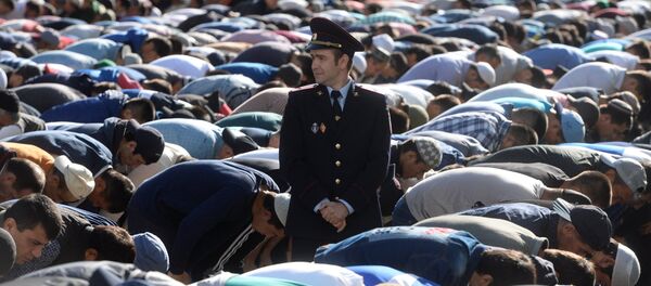 Сотрудник правоохранительных органов перед намазом в день праздника перед мечетью в Москве. Архивное фото - Sputnik Кыргызстан