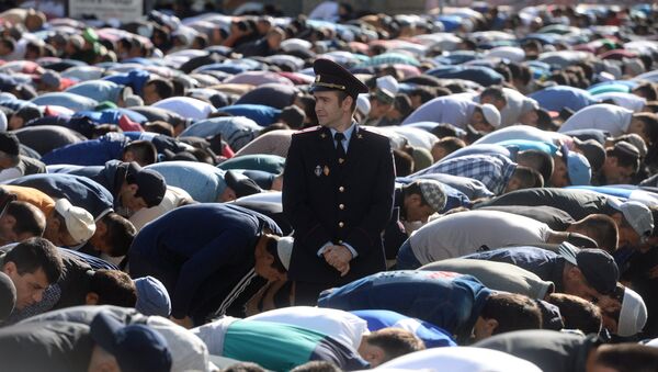 Сотрудник правоохранительных органов перед намазом в день праздника перед мечетью в Москве. Архивное фото - Sputnik Кыргызстан