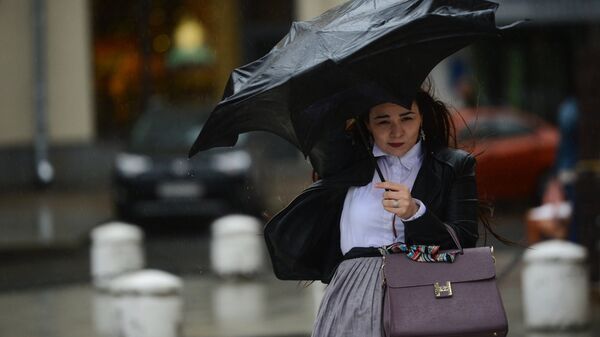 Девушка идет по площади во время дождя и сильного ветра. Архивное фото - Sputnik Кыргызстан