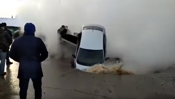 Казакстанда асфальт жарылып жолдо бараткан жеңил унаа асылып калды. Видео - Sputnik Кыргызстан