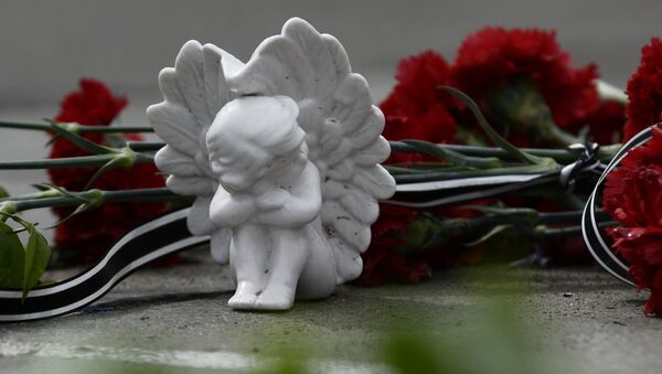 Цветы и фигурка ангела на памятнике. Архивное фото - Sputnik Кыргызстан