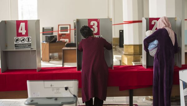 Избиратели в кабинке на избирательном участке. Архивное фото - Sputnik Кыргызстан