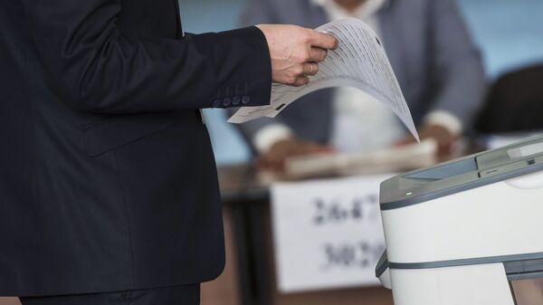 Избиратель у электронной урны на выборах. Архивное фото - Sputnik Кыргызстан