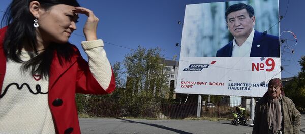 Женщины проходят мимо баннера агитирующий за кандидата в президенты КР Сооронбая Жээнбекова в Бишкеке. Архивное фото - Sputnik Кыргызстан