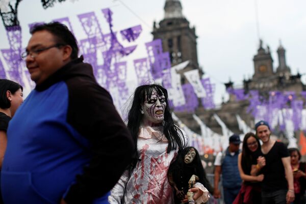 Мексиканцы 31 октября отмечают еще и День мертвых, посещают могилы умерших предков. О веселье они не думают, поэтому в Мексике проходит самый мрачный Хэллоуин.  На фото: жительница Мексики в образе ведьмы - Sputnik Кыргызстан