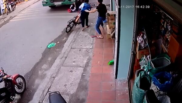 Школьник чудом не остался пол колесами грузовика — видео из Вьетнама - Sputnik Кыргызстан