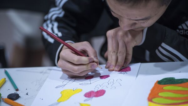 Мальчик с аутизмом рисует на бумаге. Архивное фото - Sputnik Кыргызстан
