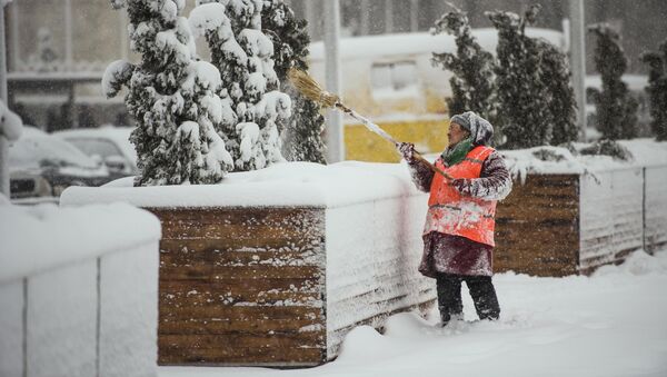 Сотрудница МП Тазалык убирает снег на одной из улиц Бишкека. Архивное фото - Sputnik Кыргызстан