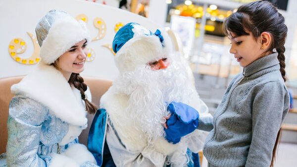 Дед Мороз и Снегурочка общаются с девочкой. Архивное фото - Sputnik Кыргызстан