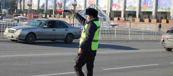 Сотрудник ГУОБДД останавливает нарушителя ПДД. Архивное фото Сотрудник ГУОБДД останавливает нарушителя ПДД. Архивное фото - Sputnik Кыргызстан