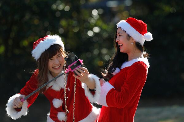 Девушки в костюмах Санта-Клаусов фотографируются во время благотворительного забега Tokyo Santa Run в Чибе. - Sputnik Кыргызстан