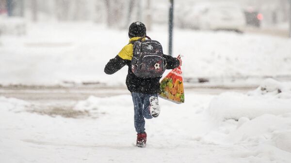 Мальчик бежит по улице во время снегопада в Бишкеке. Архивное фото - Sputnik Кыргызстан