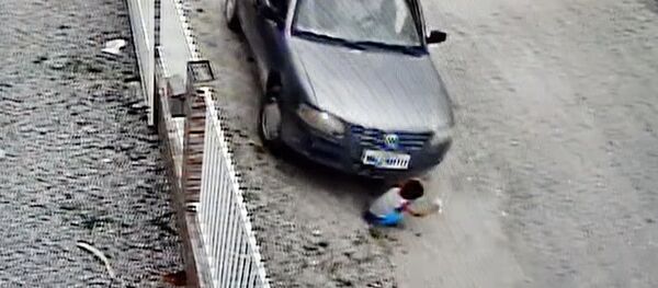 Ребенок чудом выжил, оказавшись под автомобилем, — видео из Бразилии - Sputnik Кыргызстан