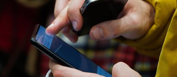 Посетитель осматривает смартфон в магазине. Архивное фото - Sputnik Кыргызстан