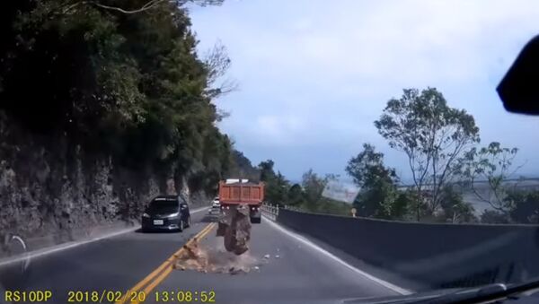 Рухнувший со скалы камень чуть не раздавил ехавшую машину — видео из Тайваня - Sputnik Кыргызстан
