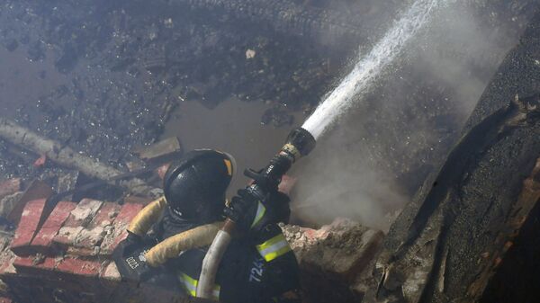 Пожарный во время тушения огня. Архивное фото - Sputnik Кыргызстан