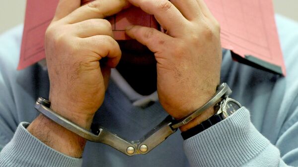 Человек в наручниках прячет лицо. Архивное фото - Sputnik Кыргызстан