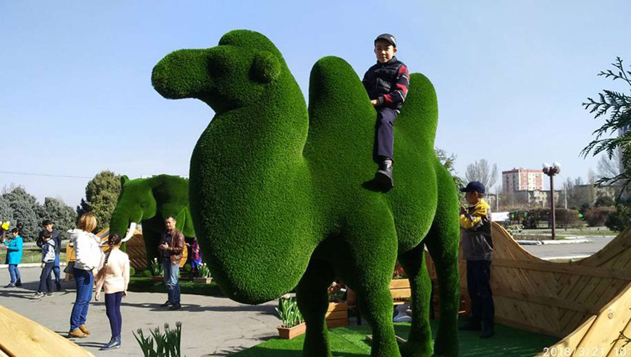 Фееричные скульптуры в форме зеленых фигур в парке