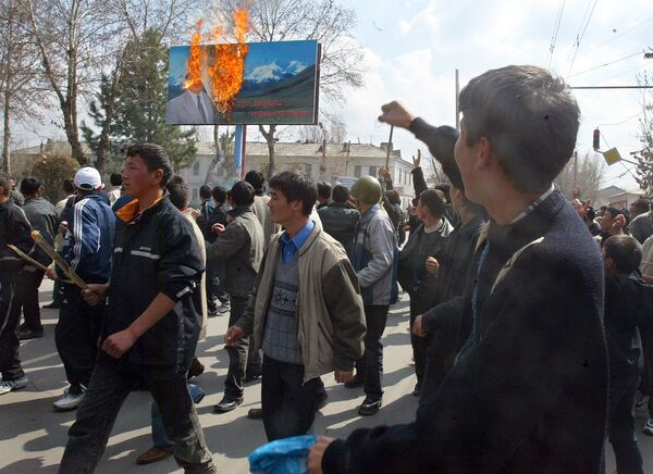 Митингге чыккан жүздөгөн адам Аскар Акаевдин күйүп жаткан сүрөтүнүн алдынан өтүп келе жатат. 2005-жыл 21-март, Ош шаары. - Sputnik Кыргызстан