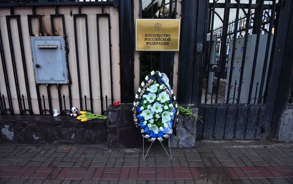 К Посольству России в КР соболезнующие кыргызстанцы, несмотря на непогоду, несут цветы и венки в связи с трагедией в Кемерово. - Sputnik Кыргызстан